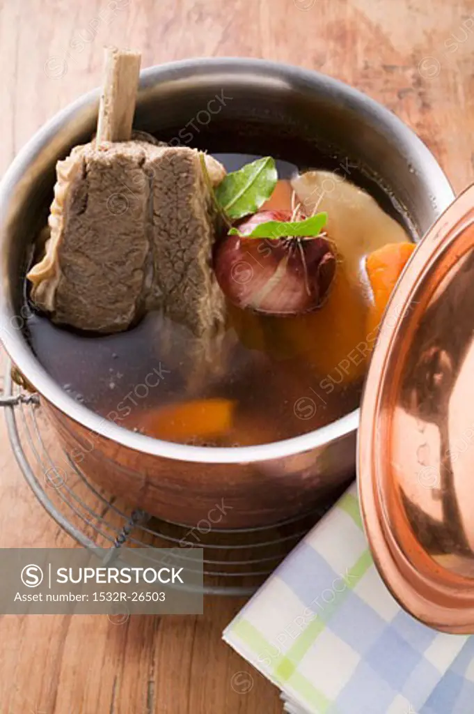 Broth with beef and soup vegetables in pot