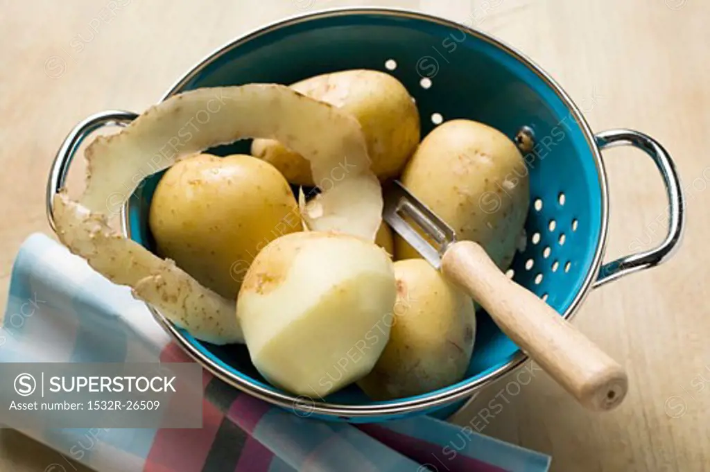 Potatoes, one half-peeled, in colander