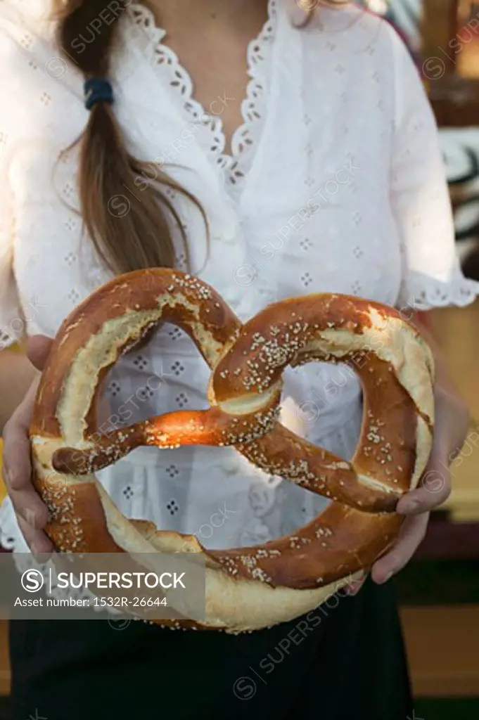 Woman holding giant pretzel at Oktoberfest