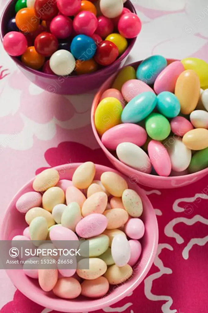 Different kinds of sweets and bubble gum balls in bowls