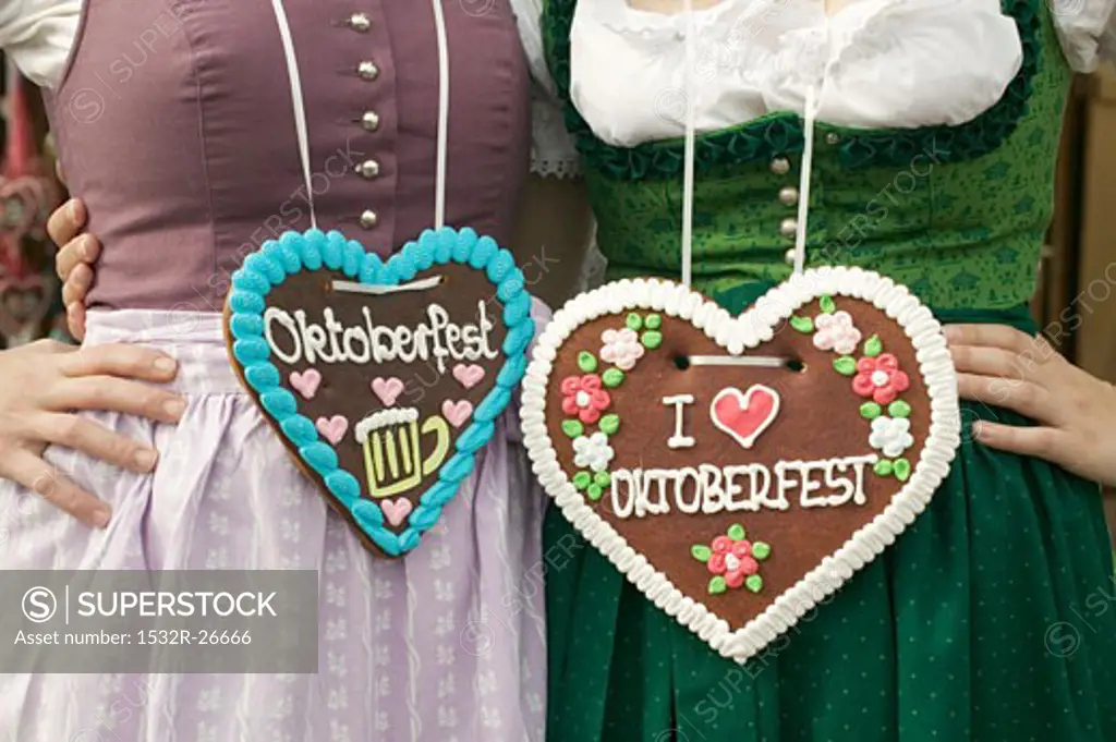 Two women in national dress with Lebkuchen hearts at Oktoberfest