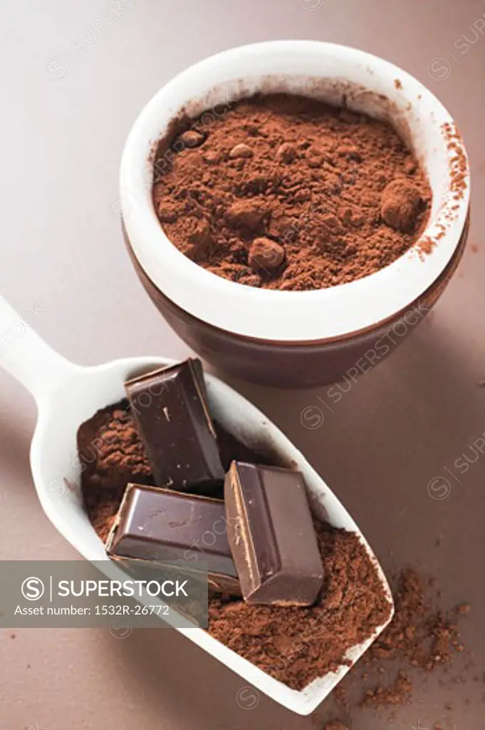 Pieces of chocolate and cocoa powder in scoop and bowl