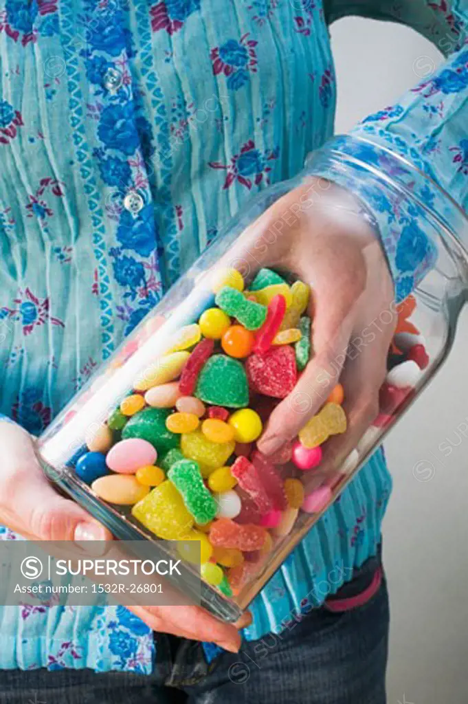 Hand taking sweets out of jar