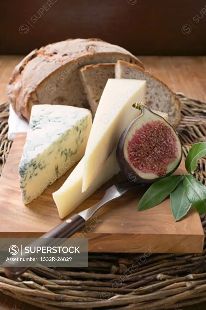 Various types of cheese, bread and half a fig