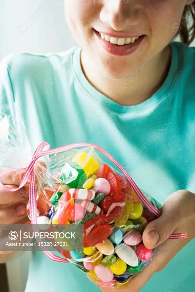 Woman holding cellophane bag of coloured sweets