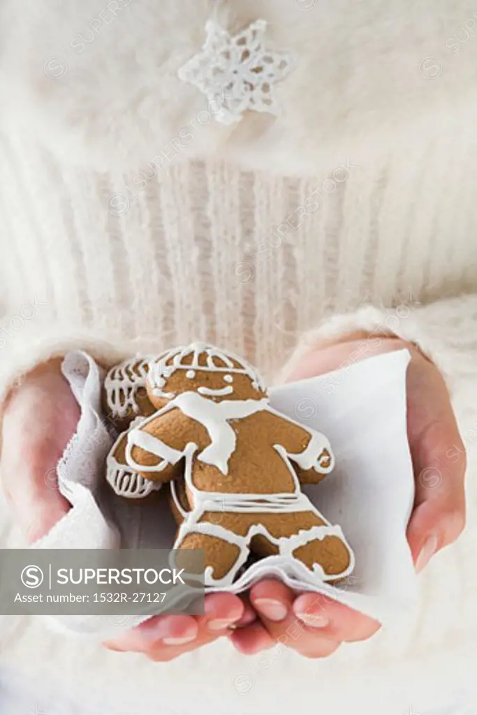 Hands holding two gingerbread men