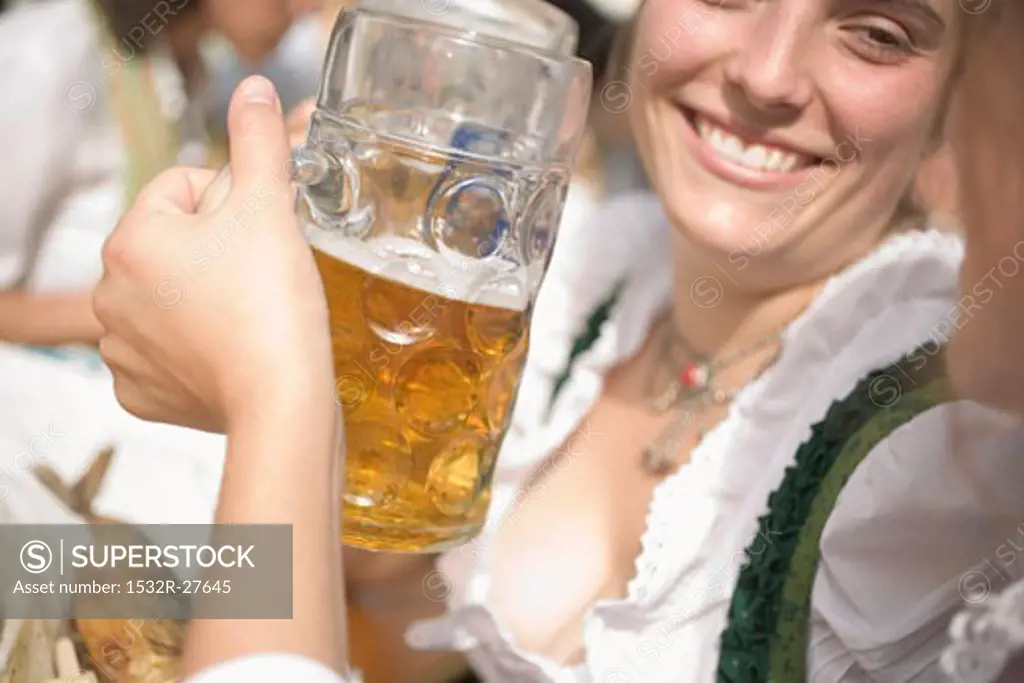 Women clinking two litres of beer together (Oktoberfest, Munich)