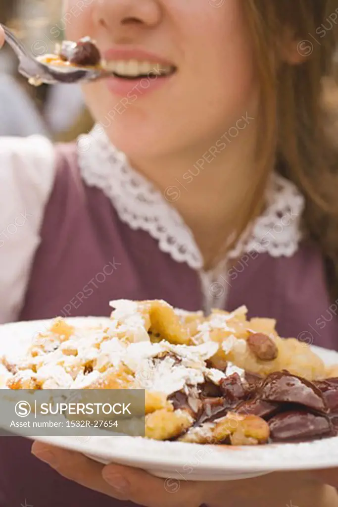 Woman eating Emperor's pancake (Oktoberfest, Munich)