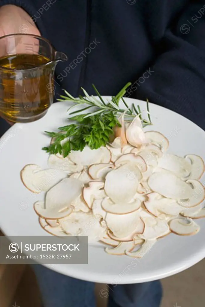 Person holding plate of ingredients for cep carpaccio