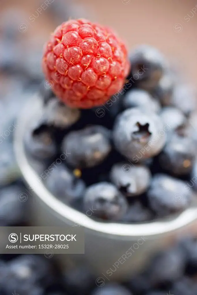 Raspberry and blueberries with plastic beaker