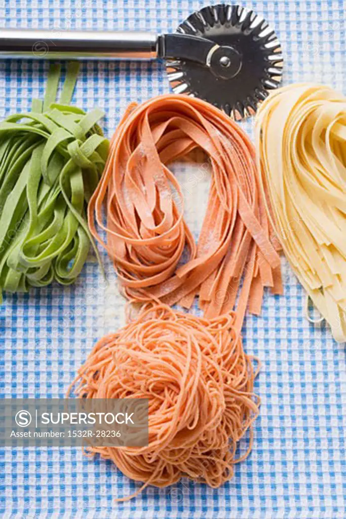 Various types of home-made pasta with pastry wheel