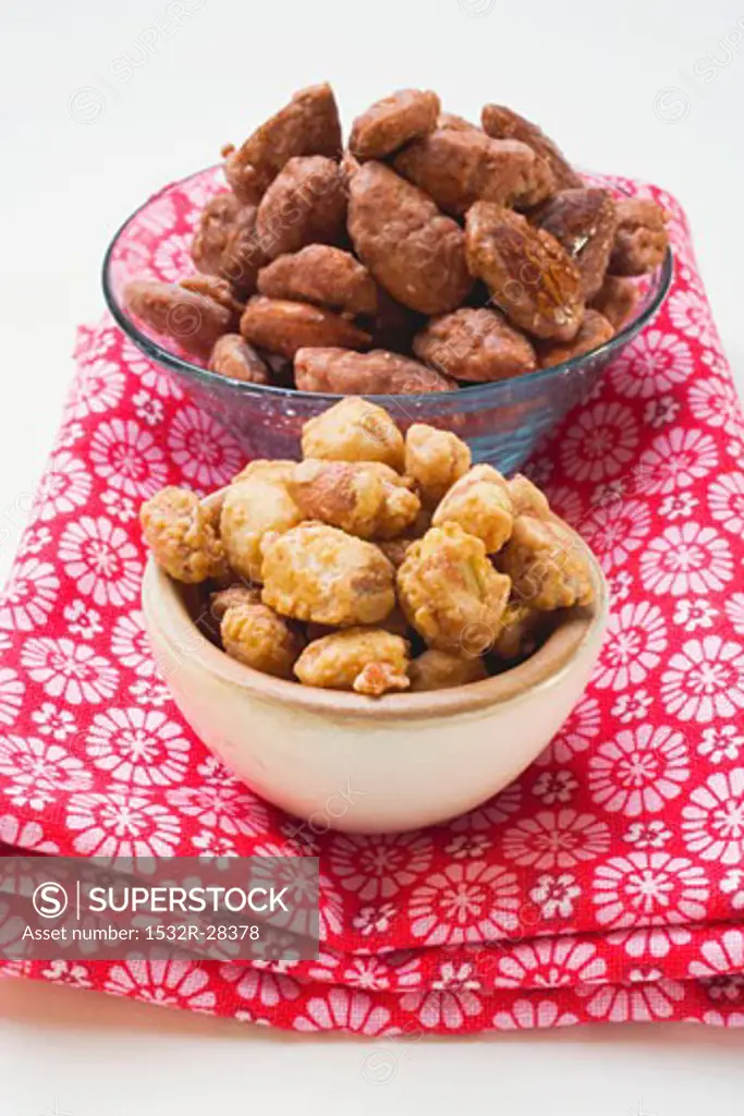 Assorted nuts to nibble in bowls on patterned cloth