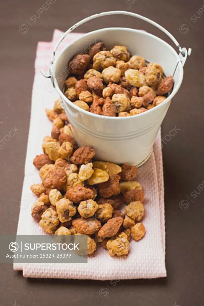 Mixed nuts to nibble in and beside white bucket