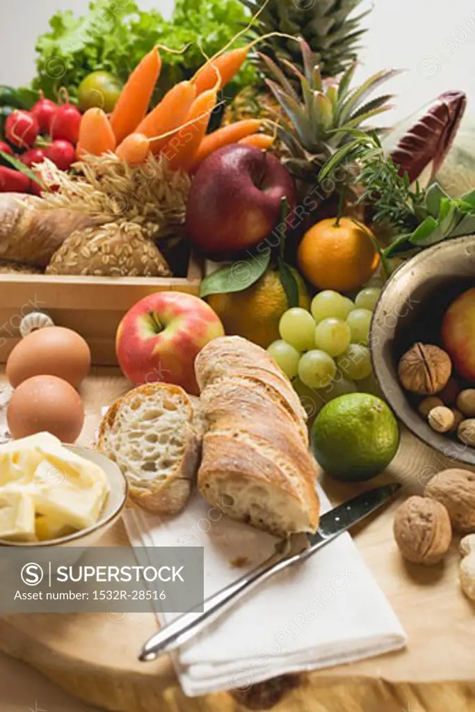 Still life with vegetables, fruit, eggs, butter, nuts, baguette