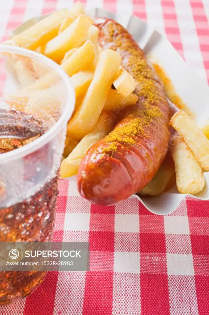 Sausage with ketchup & curry powder & chips in paper dish, cola