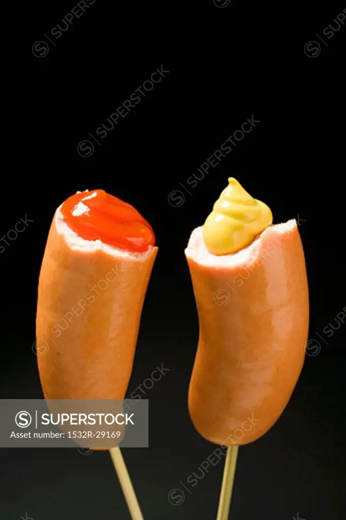 Two half frankfurters with mustard and ketchup