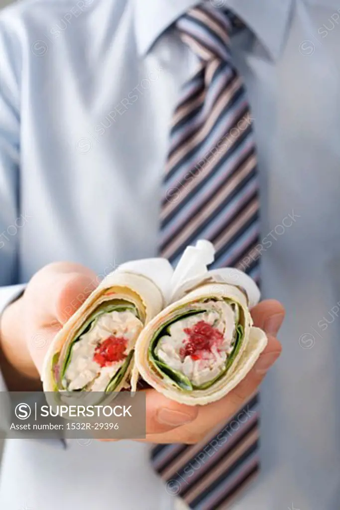 Man in tie holding two wraps