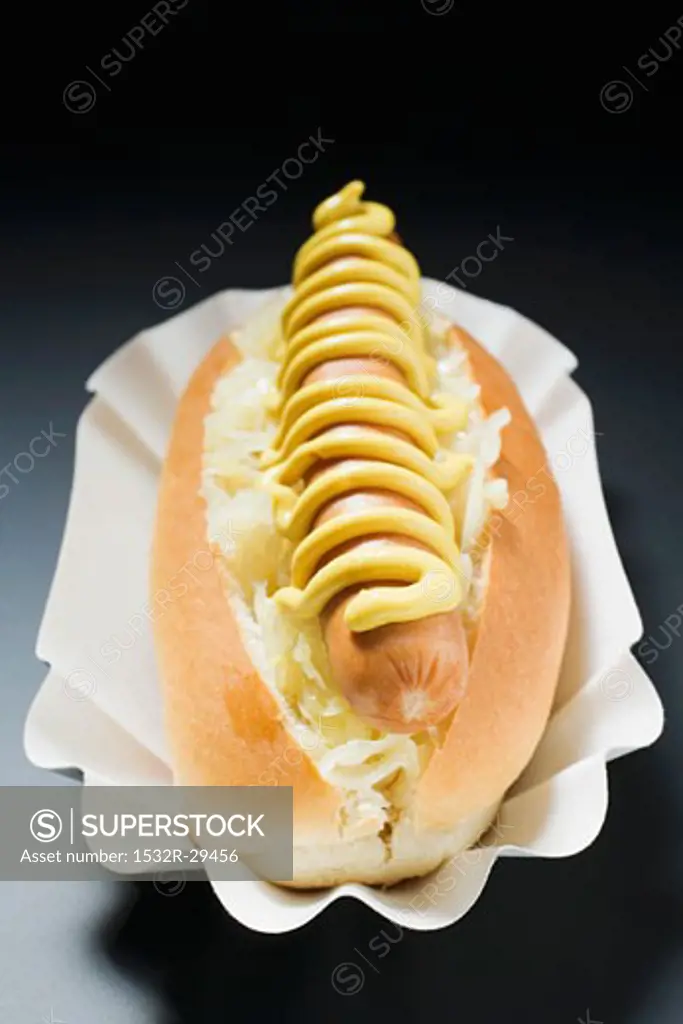 Hot dog with sauerkraut and mustard in paper dish