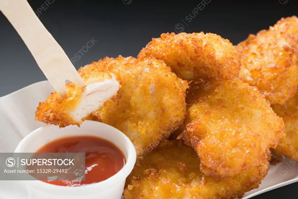 Chicken nuggets with ketchup in paper dish