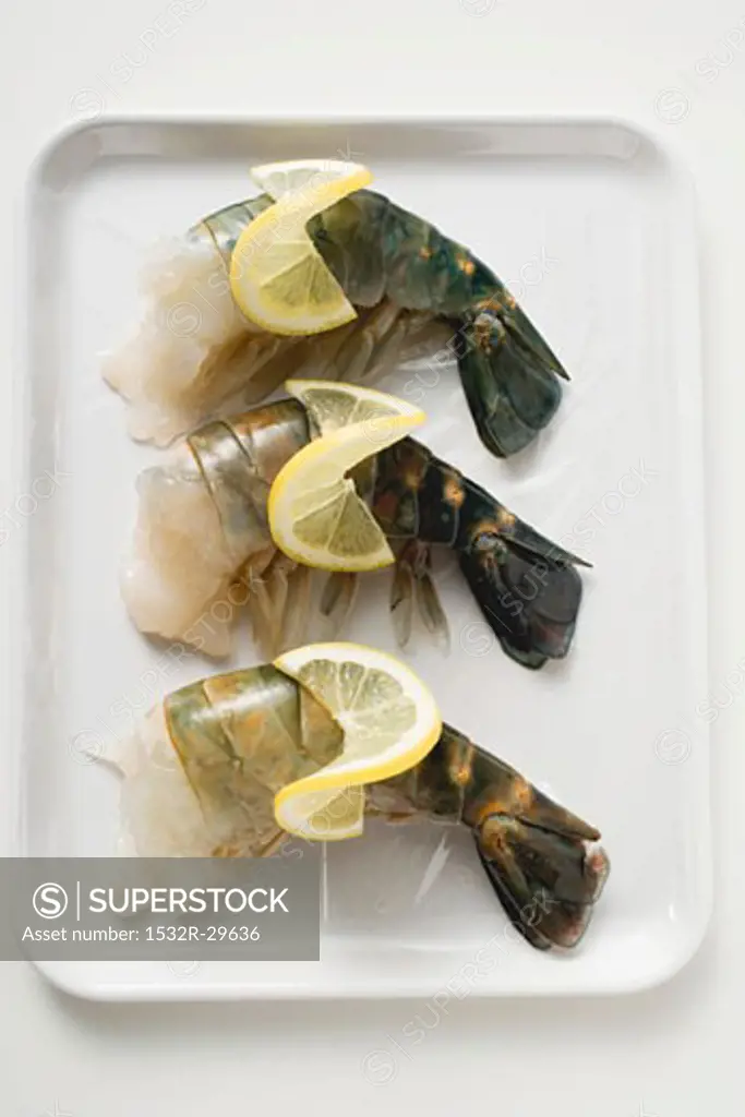 Fresh king prawns with lemon slices on tray