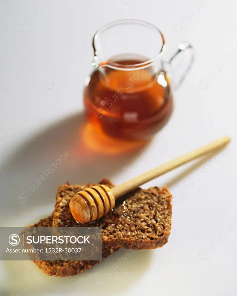 Wholegrain bread with honey and honey dipper
