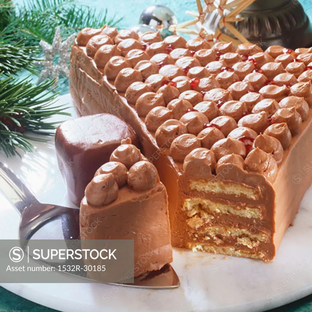 Chocolate cream cake in shape of Christmas tree, a piece cut