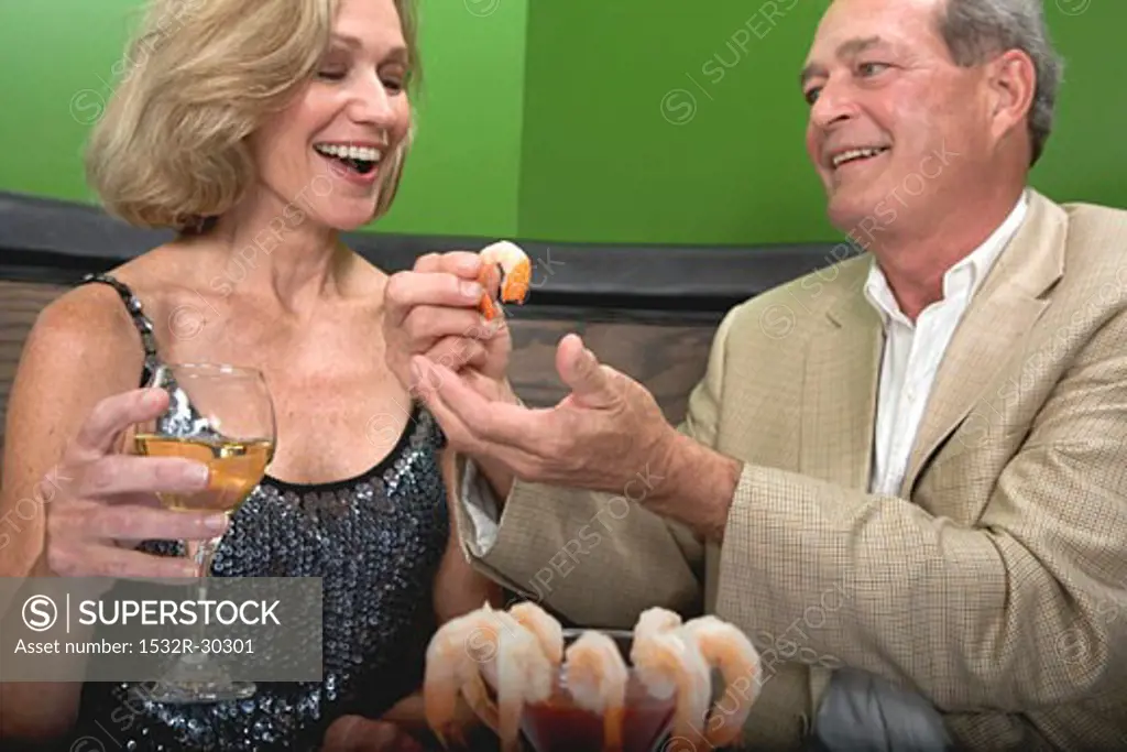 Man and woman eating shrimps in restaurant