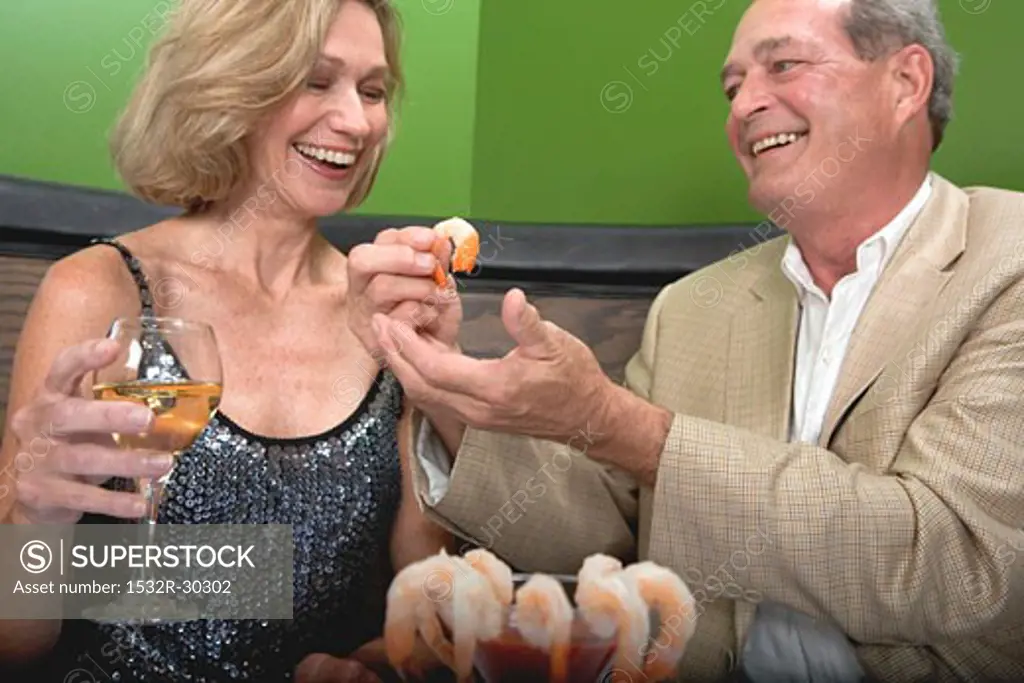 Man and woman eating shrimps in restaurant