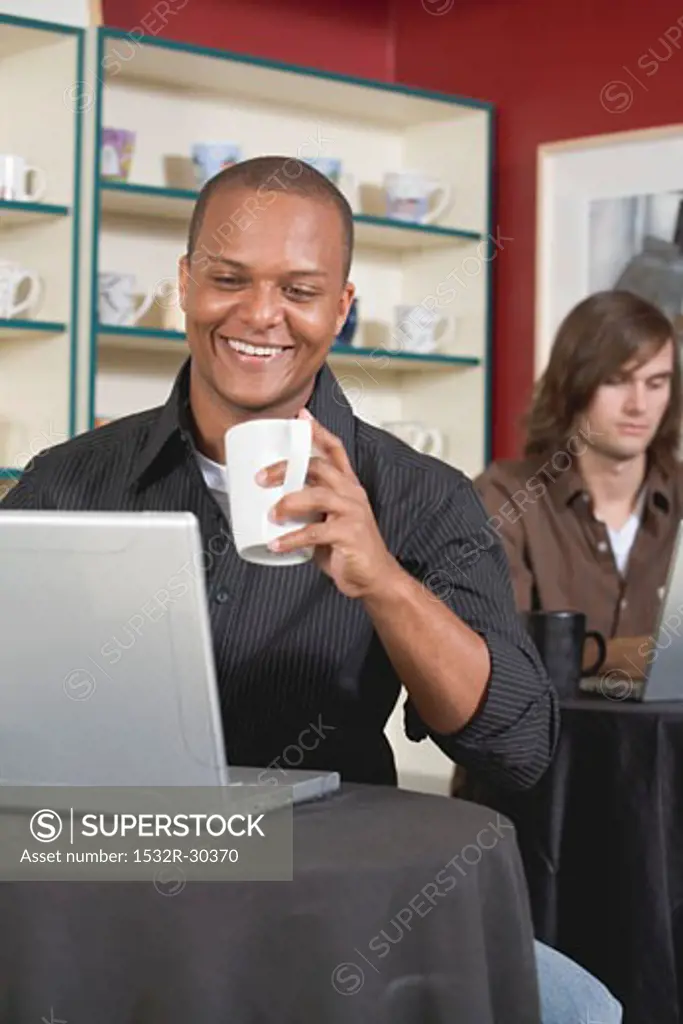 Young man at laptop in a café