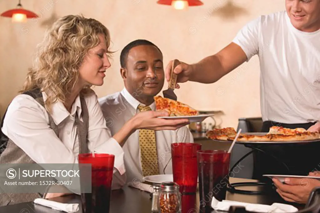 Man serving pizza to customers