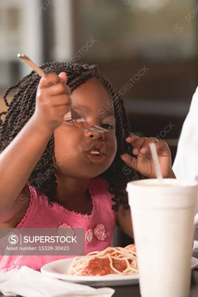 Girl eating spaghetti with mince sauce