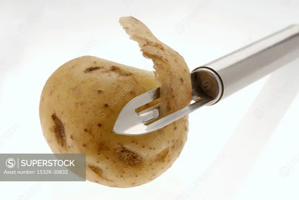 Potato with potato peeler
