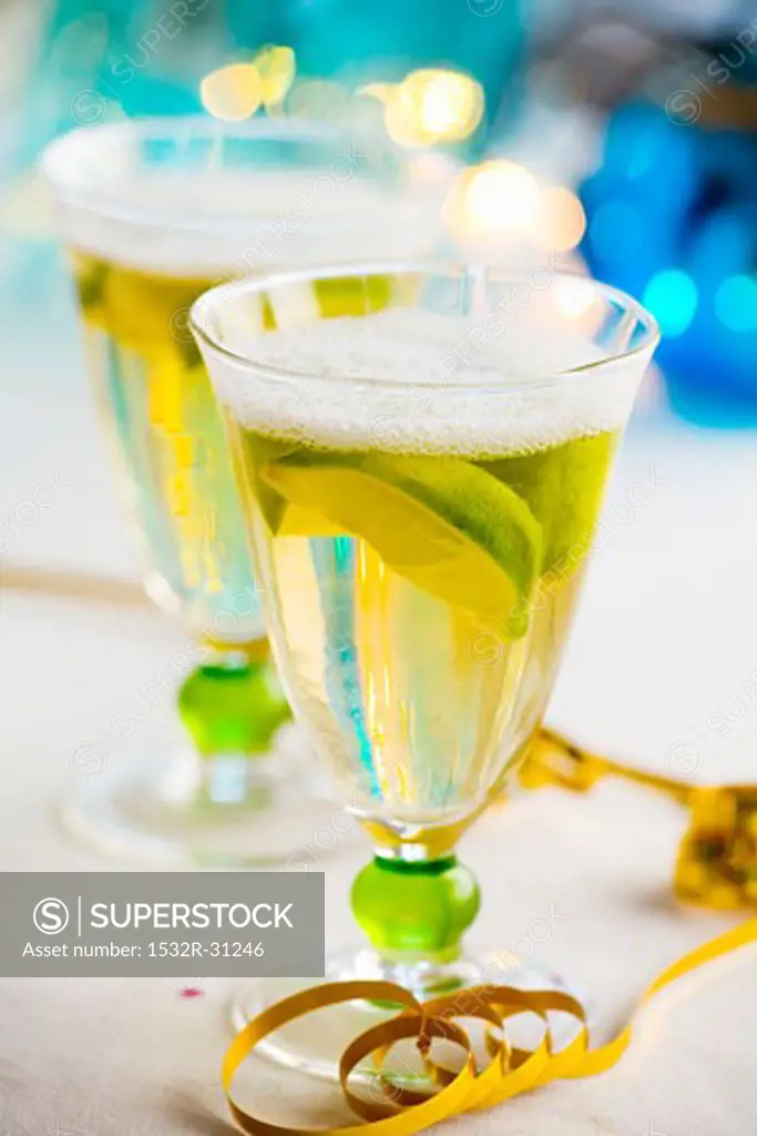 Two glasses of sparkling wine with lemon wedges