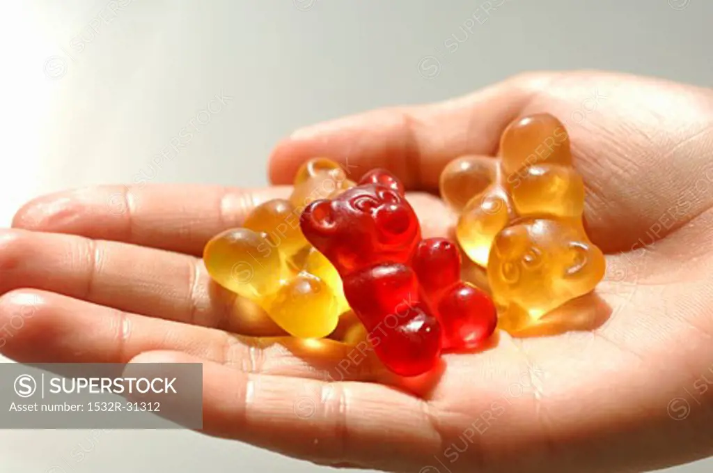 Three gummi bears in someone's hand