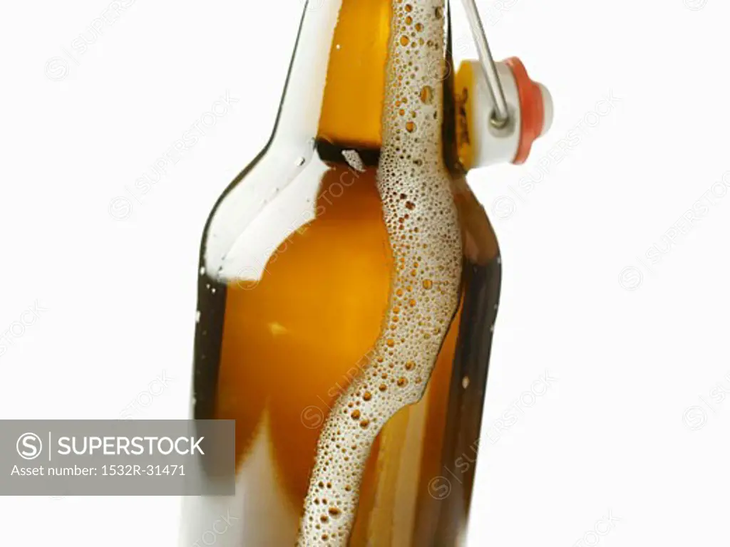 Flip-top bottle with beer frothing out