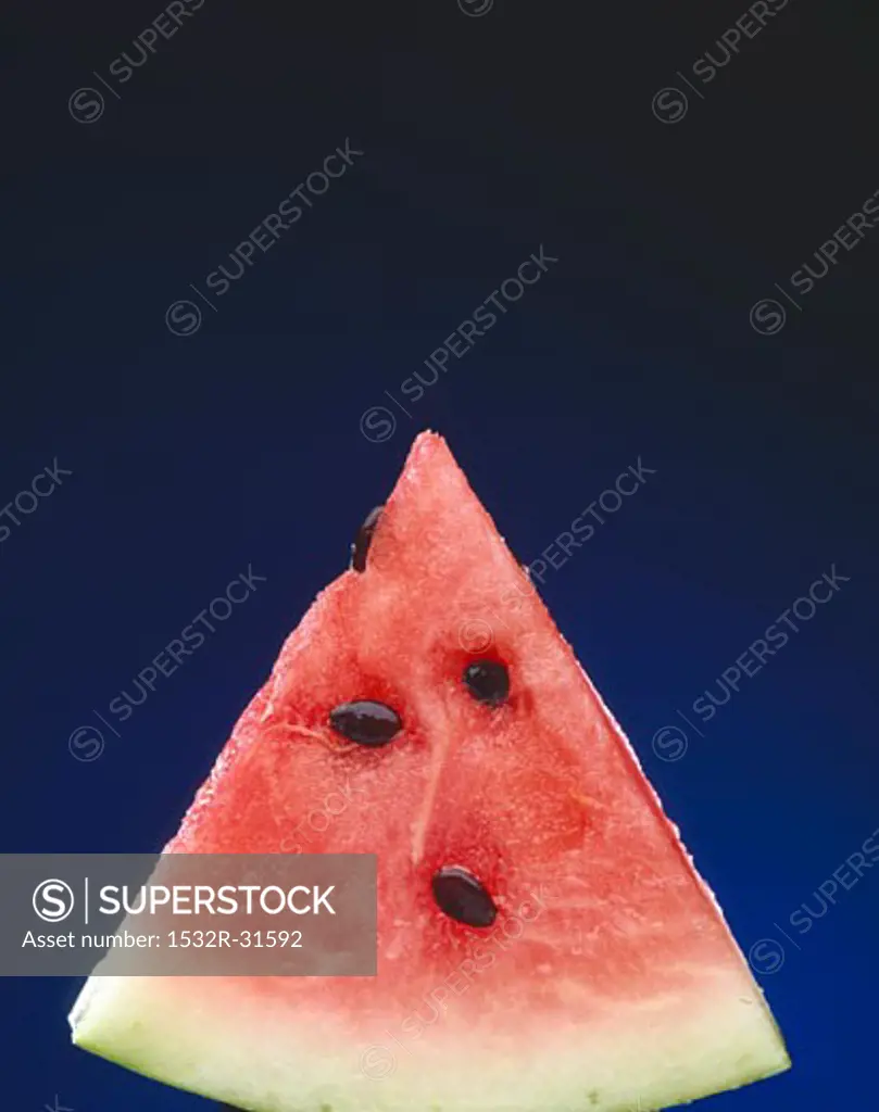 Slice of Watermelon with Seeds on a Blue Background