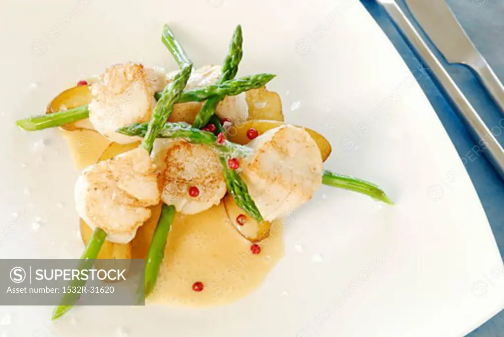 Scallops speared on asparagus with butter sauce