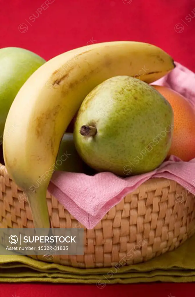 Pears, banana and grapefruit in fruit basket