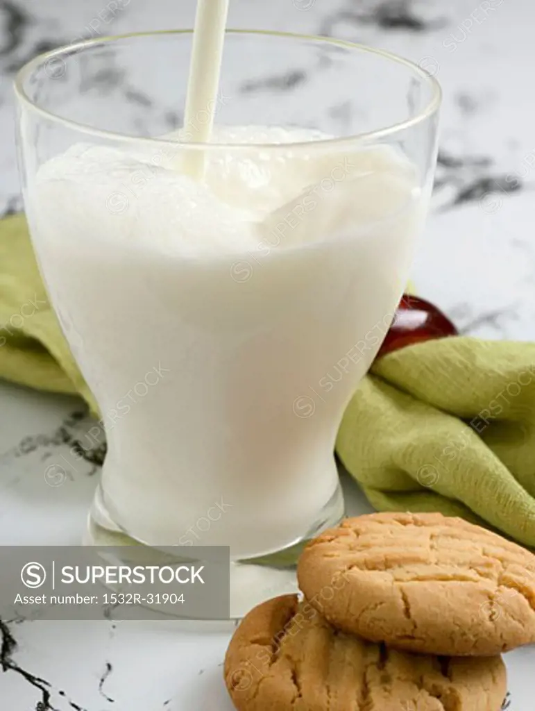 A glass of milk with two peanut butter biscuits
