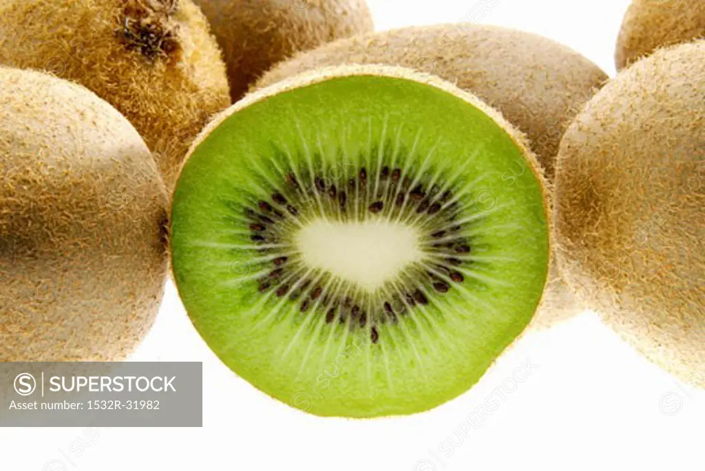 Half a kiwi fruit surrounded by whole fruit