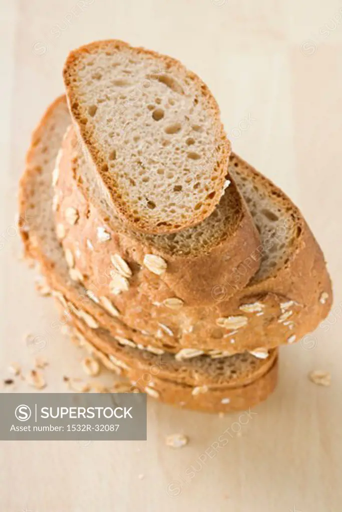 Slices of oat bread in a pile on a wooden table