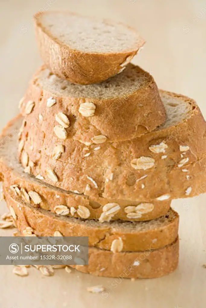 Slices of oat bread in a pile on a wooden table