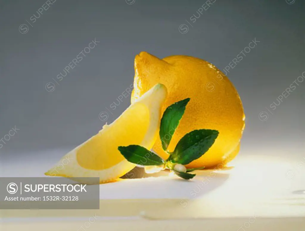 Whole lemon and lemon wedge, lemon leaves