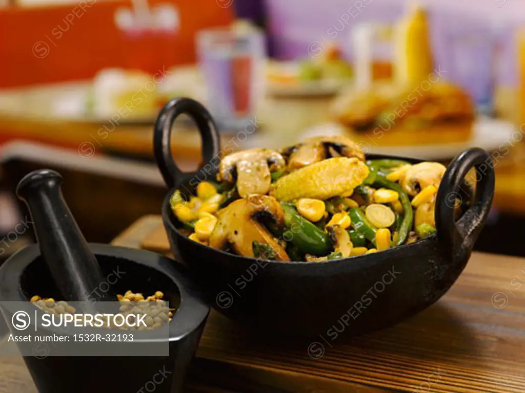 Stir-fried mushrooms, sweetcorn and beans in a small pan