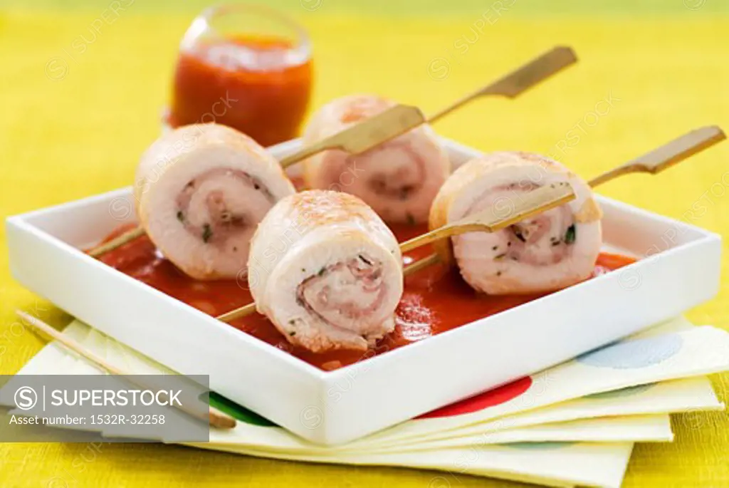Four chicken breast roulades on tomato sauce