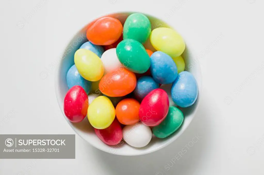Coloured sugar eggs in white dish