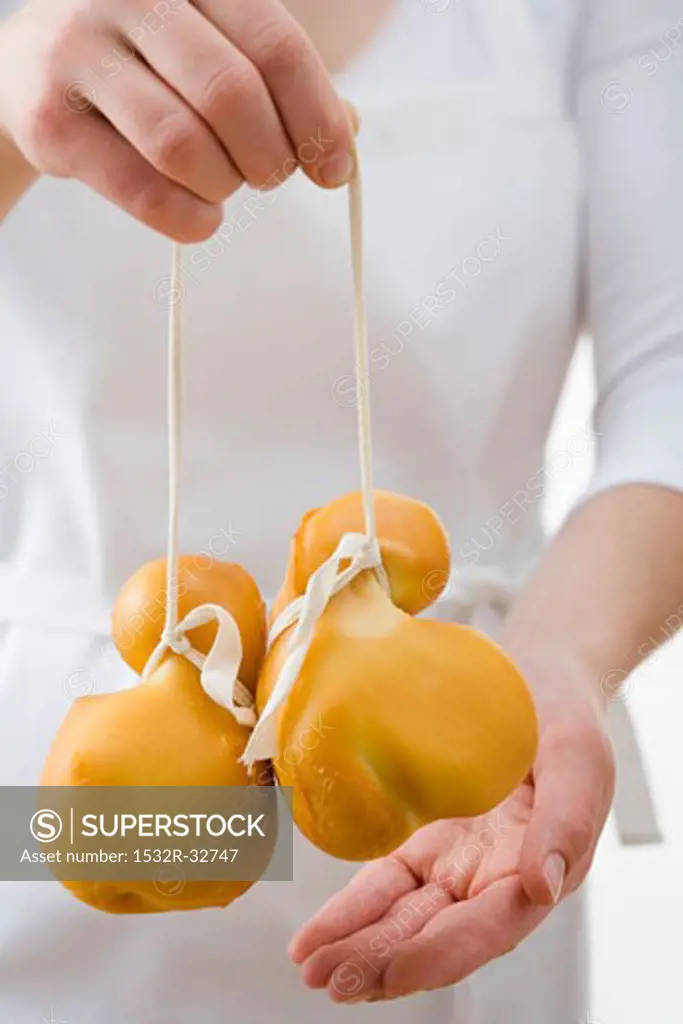 Woman holding two Provolone cheeses