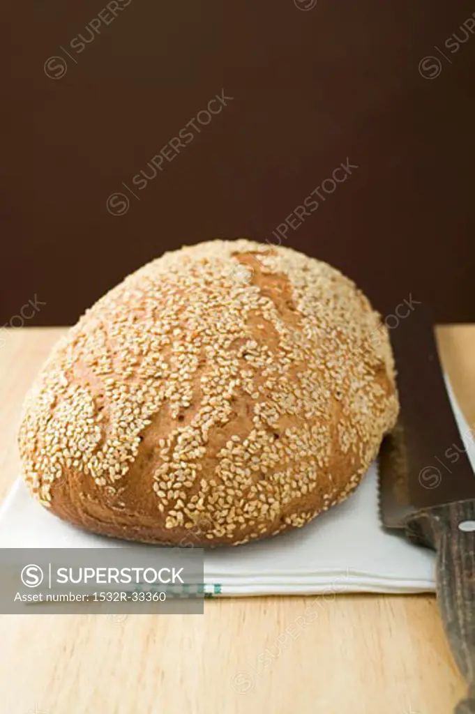 Sesame bread on tea towel with bread knife