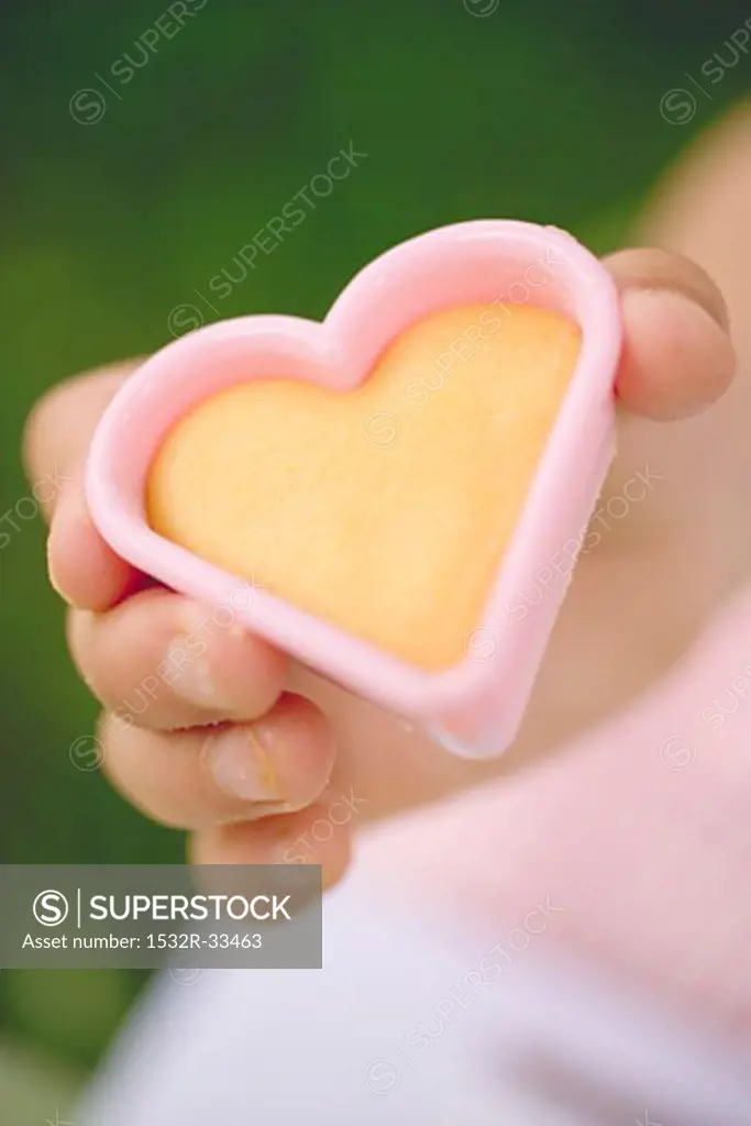 Child holding cut-out biscuit