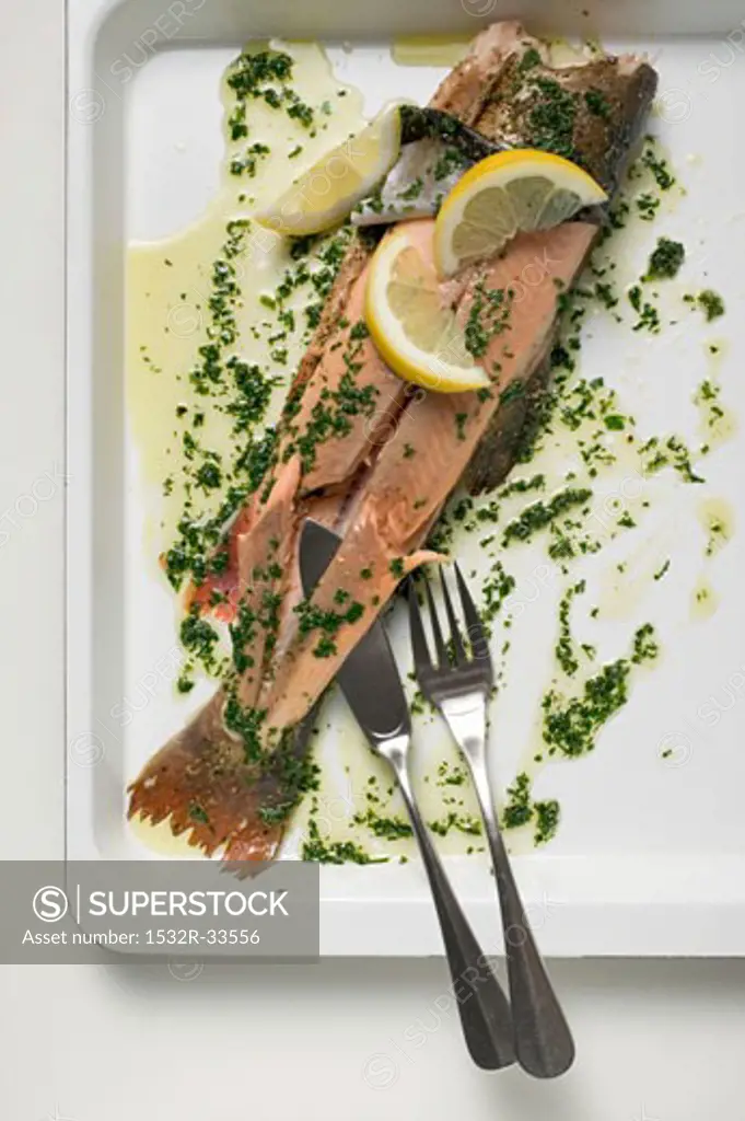 Salmon trout with herb butter and lemon wedges
